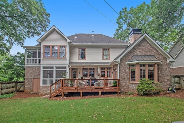 rear view of house with a wooden deck and a yard