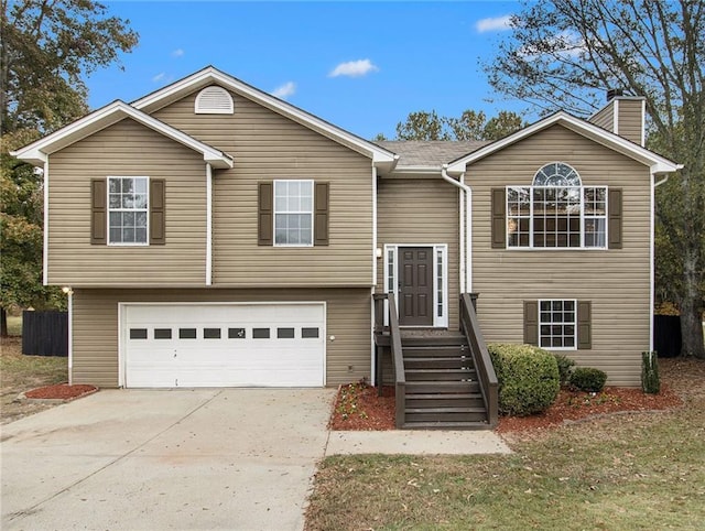 split foyer home featuring a front lawn and a garage