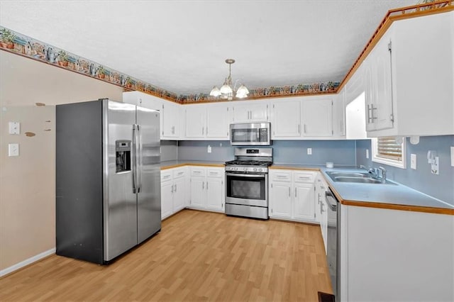 1341 Little Deer Run, Canton, GA 30114 - kitchen with appliances with stainless steel finishes, a chandelier, light wood-type flooring, and white cabinetry
