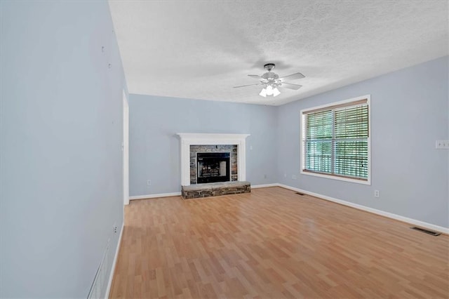 1341 Little Deer Run, Canton, GA 30114 - unfurnished living room featuring a ceiling fan, light wood finished floors, a textured ceiling, and a fireplace
