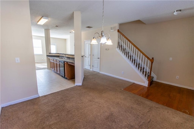 1830 Bayrose Cir Unit 30B, East Point, GA 30344 - kitchen featuring a notable chandelier, baseboards, black dishwasher, a sink, and light colored carpet