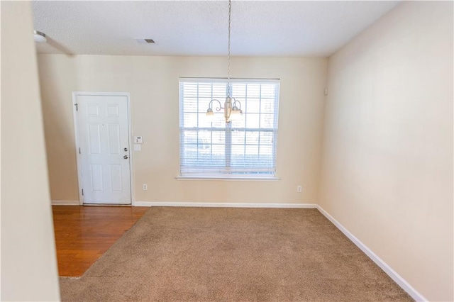 1830 Bayrose Cir Unit 30B, East Point, GA 30344 - unfurnished dining area with carpet, an inviting chandelier, a textured ceiling, visible vents, and baseboards