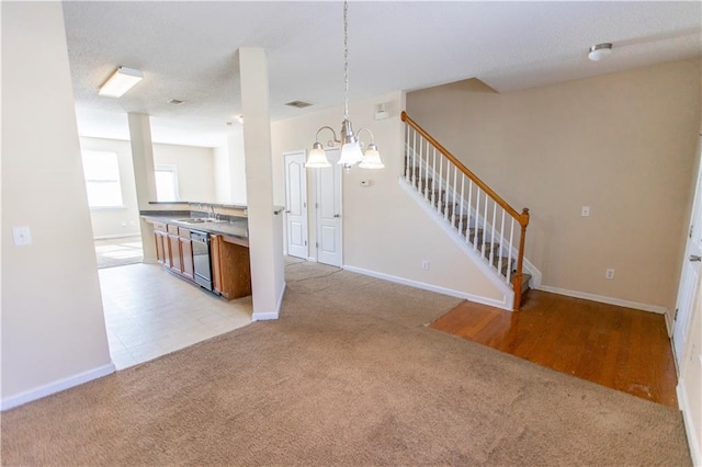 1830 Bayrose Cir Unit 30B, East Point, GA 30344 - kitchen with baseboards, black dishwasher, an inviting chandelier, a sink, and light colored carpet