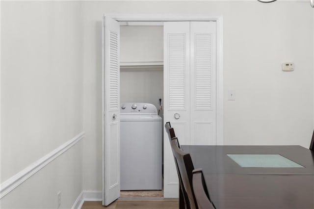 laundry area featuring washer / dryer, baseboards, laundry area, and wood finished floors