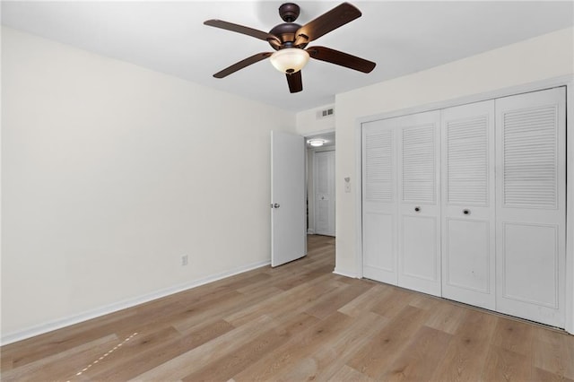 unfurnished bedroom featuring light wood finished floors, a closet, visible vents, a ceiling fan, and baseboards