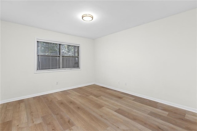 spare room with light wood-type flooring and baseboards