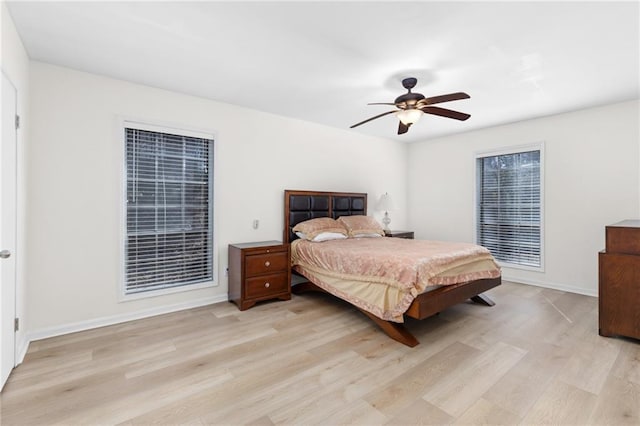 bedroom featuring a ceiling fan, baseboards, and light wood finished floors