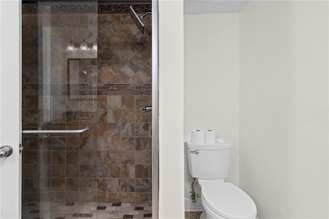 full bathroom featuring a stall shower and toilet