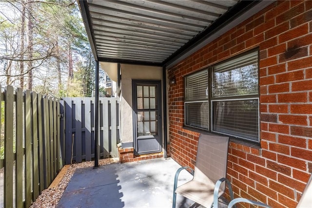 property entrance featuring brick siding and fence