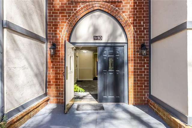 view of exterior entry with brick siding