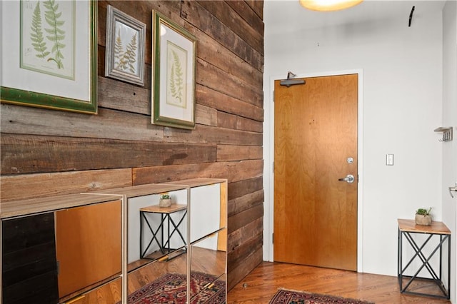 entryway featuring light hardwood / wood-style floors and wood walls