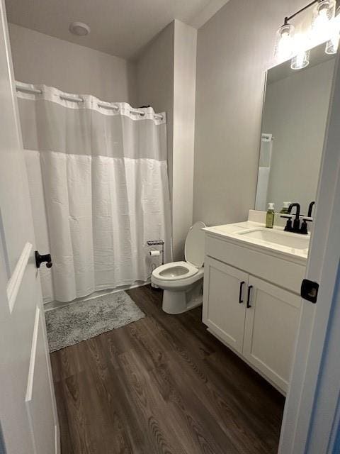 bathroom with vanity, toilet, and hardwood / wood-style floors