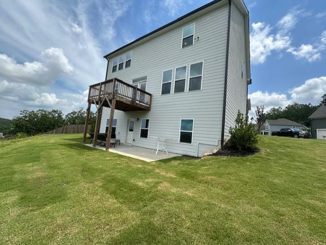 rear view of property featuring a lawn and a patio area