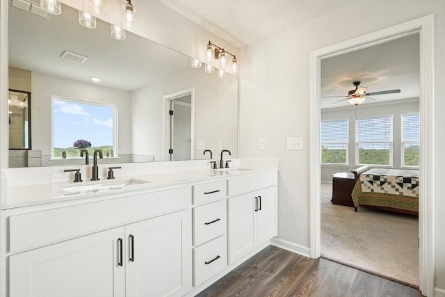 bathroom with dual vanity, wood-type flooring, and ceiling fan