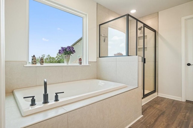 bathroom with separate shower and tub, wood-type flooring, and a wealth of natural light