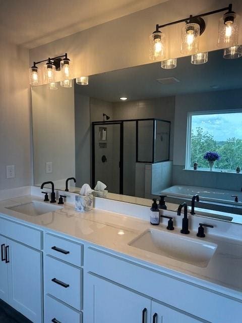 bathroom with dual vanity and independent shower and bath