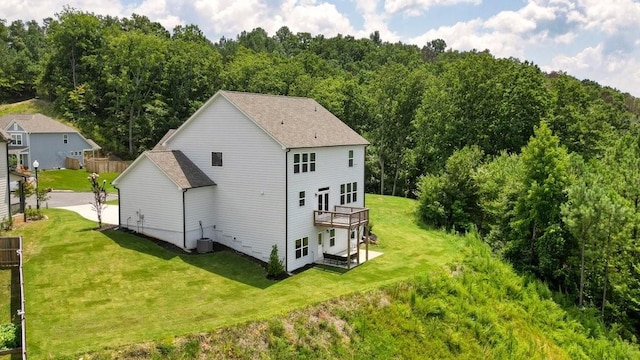 rear view of property featuring a wooden deck, a yard, and central air condition unit