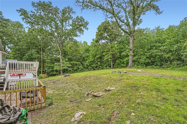 view of yard with a view of trees and a wooden deck