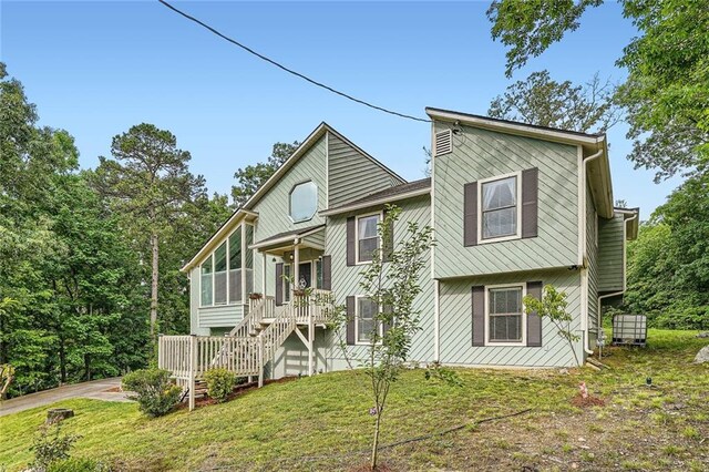 back of property featuring a lawn and stairway