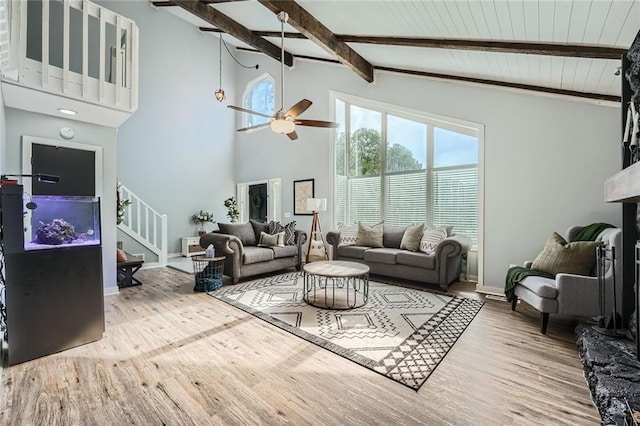 living room with high vaulted ceiling, beamed ceiling, stairs, and wood finished floors