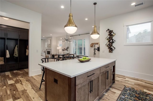 1168 Mado Loop, Chattahoochee Hills, GA 30268 - kitchen featuring a breakfast bar, light wood-type flooring, baseboards, light countertops, and recessed lighting
