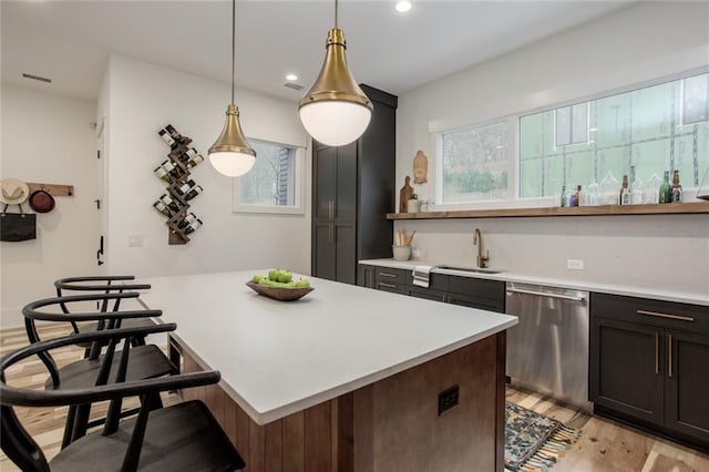 1168 Mado Loop, Chattahoochee Hills, GA 30268 - kitchen featuring dishwasher, a sink, light wood-type flooring, light countertops, and a breakfast bar area
