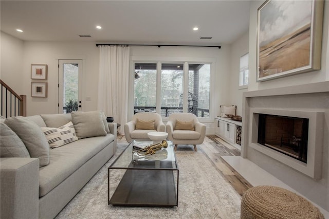 1168 Mado Loop, Chattahoochee Hills, GA 30268 - living area with a fireplace with flush hearth, wood finished floors, recessed lighting, stairway, and plenty of natural light