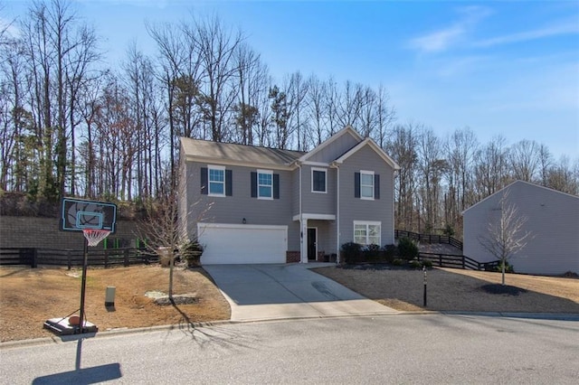 traditional home with a garage, concrete driveway, and fence