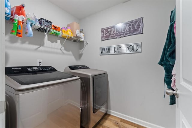 washroom with light hardwood / wood-style floors and washer and dryer