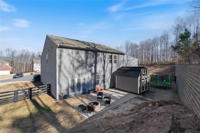 exterior space featuring an outdoor fire pit, a shed, and a patio area