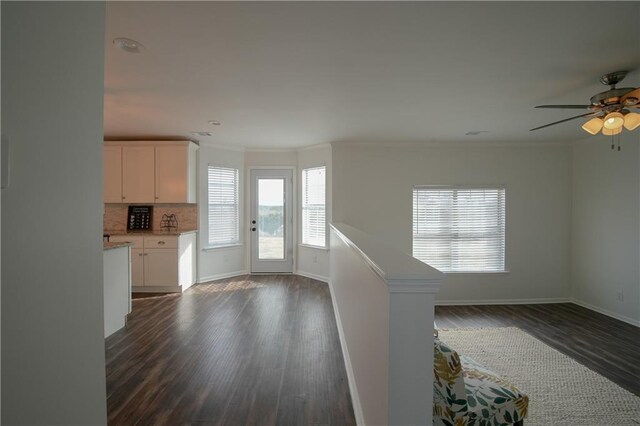 unfurnished living room with ceiling fan, crown molding, and dark hardwood / wood-style flooring