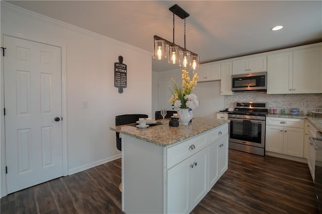 kitchen featuring a center island, hanging light fixtures, appliances with stainless steel finishes, light stone countertops, and white cabinets