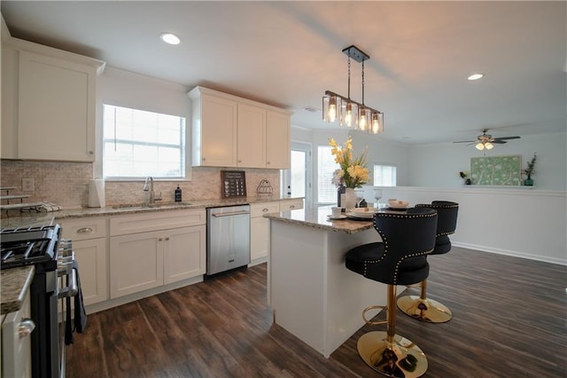 kitchen with a kitchen island, sink, white cabinets, and appliances with stainless steel finishes