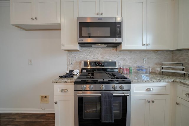 kitchen with tasteful backsplash, light stone countertops, appliances with stainless steel finishes, and white cabinetry