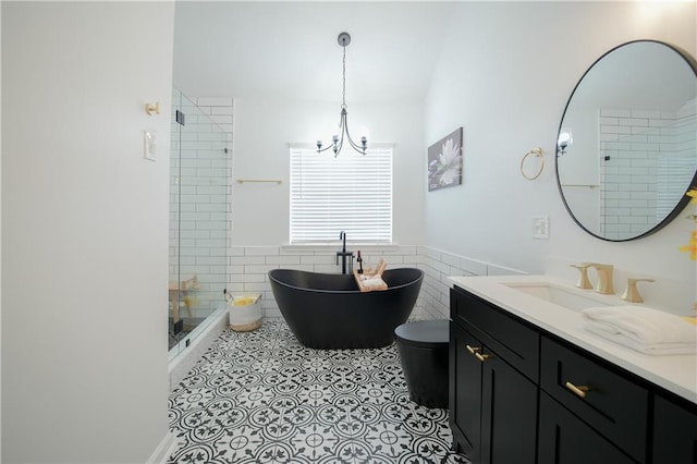 bathroom featuring independent shower and bath, tile walls, a chandelier, vanity, and tile patterned floors