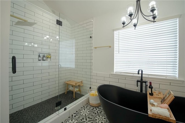 bathroom with separate shower and tub, tile walls, and a notable chandelier