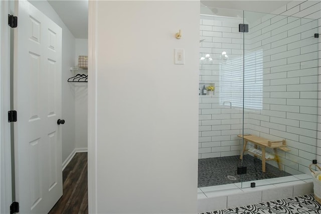 bathroom with a shower with door and hardwood / wood-style floors