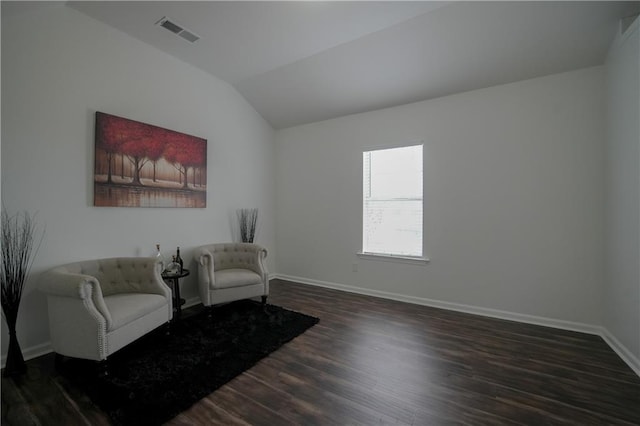 sitting room with vaulted ceiling and dark wood-type flooring