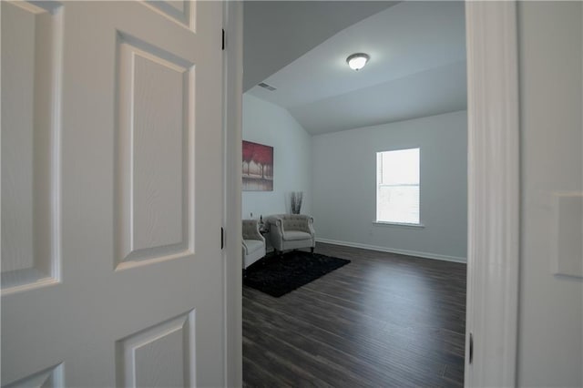 sitting room with lofted ceiling and dark wood-type flooring