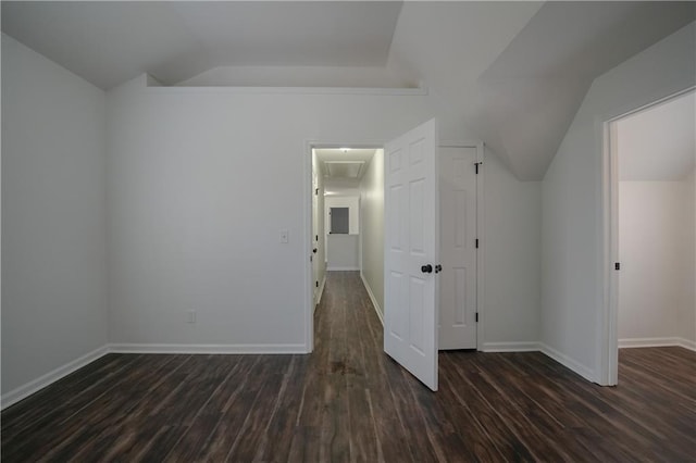 interior space featuring dark wood-type flooring and vaulted ceiling