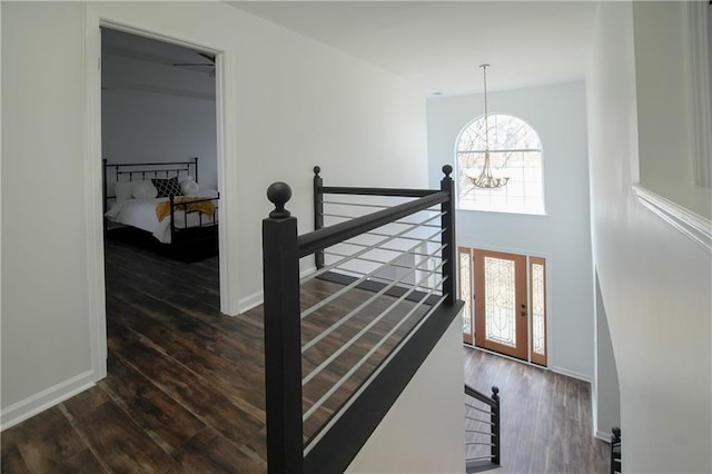 stairs featuring hardwood / wood-style floors and a notable chandelier