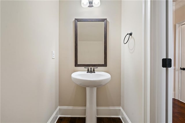 bathroom with baseboards, a sink, and wood finished floors