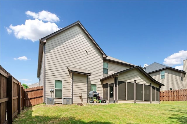 back of property with a lawn, central AC unit, a sunroom, and a fenced backyard