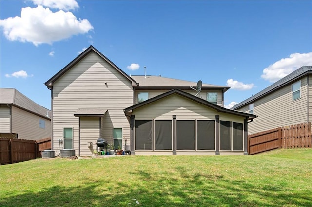 back of house featuring a lawn, a fenced backyard, and a sunroom