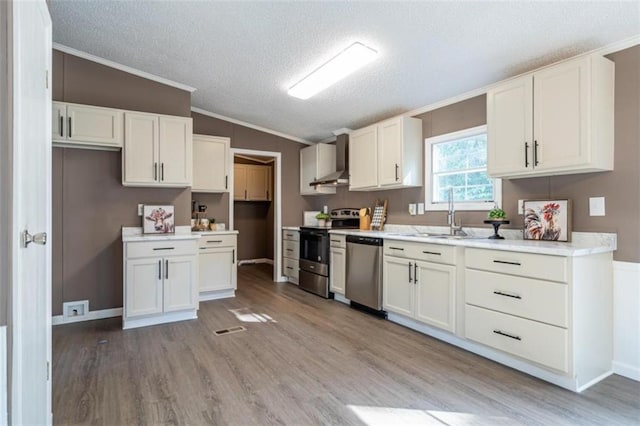 kitchen with light wood-type flooring, white cabinetry, stainless steel appliances, lofted ceiling, and crown molding