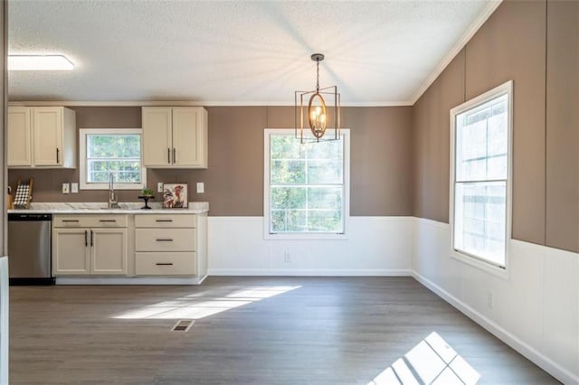 kitchen with dishwasher, sink, crown molding, decorative light fixtures, and dark hardwood / wood-style flooring