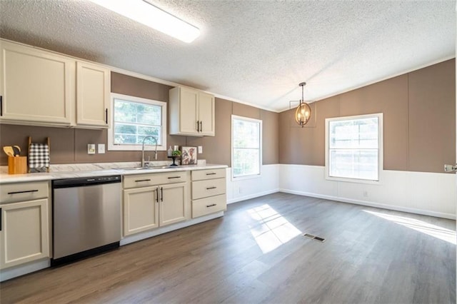 kitchen featuring stainless steel dishwasher, wood-type flooring, vaulted ceiling, sink, and decorative light fixtures