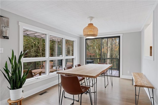 dining space featuring hardwood / wood-style floors and ornamental molding