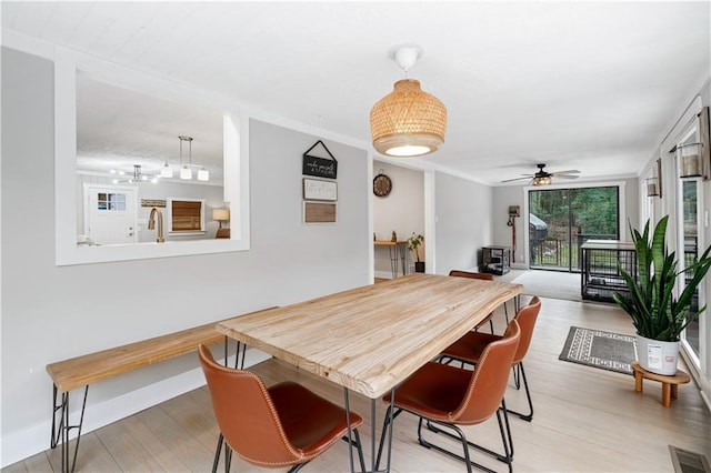 dining room featuring ceiling fan, crown molding, and light wood-type flooring