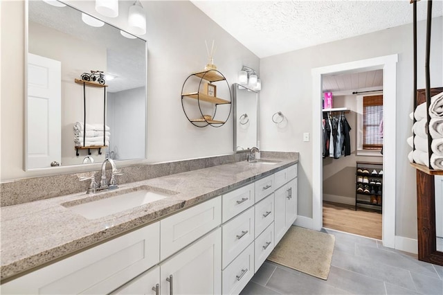 bathroom featuring tile patterned floors, vanity, and a textured ceiling